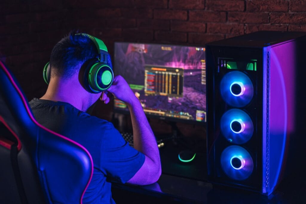 Cum îți îmbunătățește RGB-ul experiența de gaming? Gamer jucând la un PC cu RGB sincronizat, pentru o experiență vizuală mai captivantă.