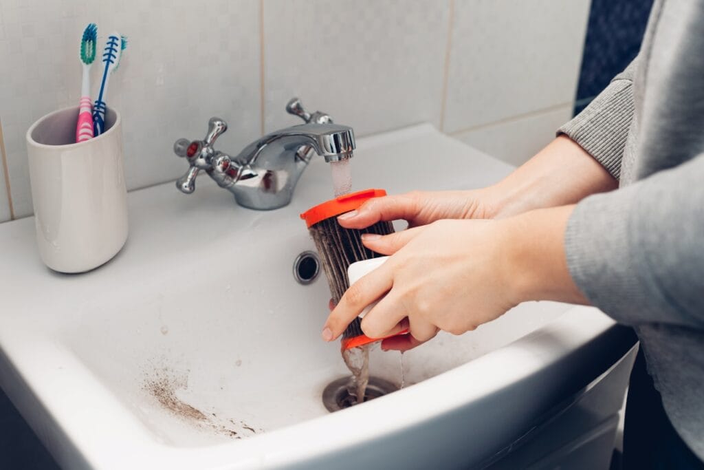 Curățarea corectă a filtrului aspiratorului pentru performanță maximă Îndepărtarea murdăriei din filtrul aspiratorului prin spălare cu apă, ghid de întreținere.