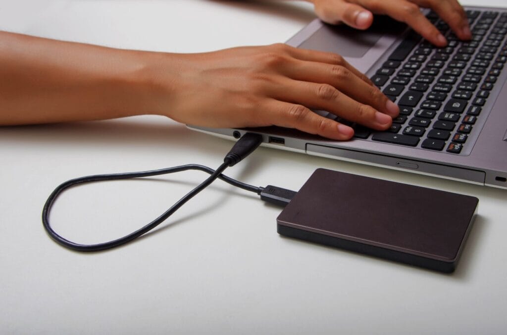 Vrei să nu mai pierzi fișiere importante? Fă backup automat! Hard disk extern conectat la laptop pentru realizarea backup-ului automat, protecție digitală eficientă