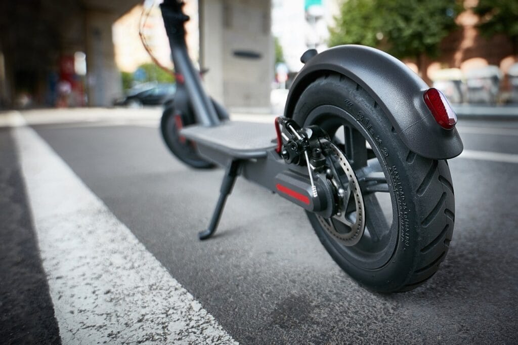 Detaliu roată spate trotinetă electrică cu frână pe disc, lumină LED și anvelope late pentru stabilitate