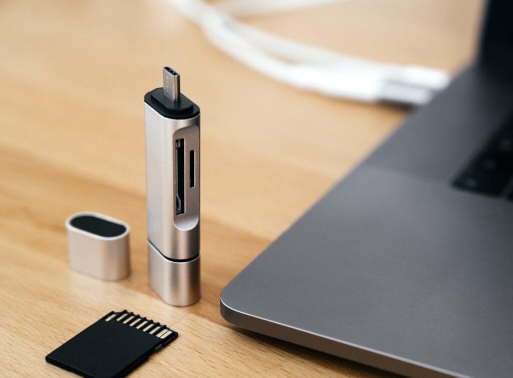 Cititor de carduri USB-C modern lângă laptop, alături de un card SD, potrivit pentru utilizare cu dispozitive mobile.