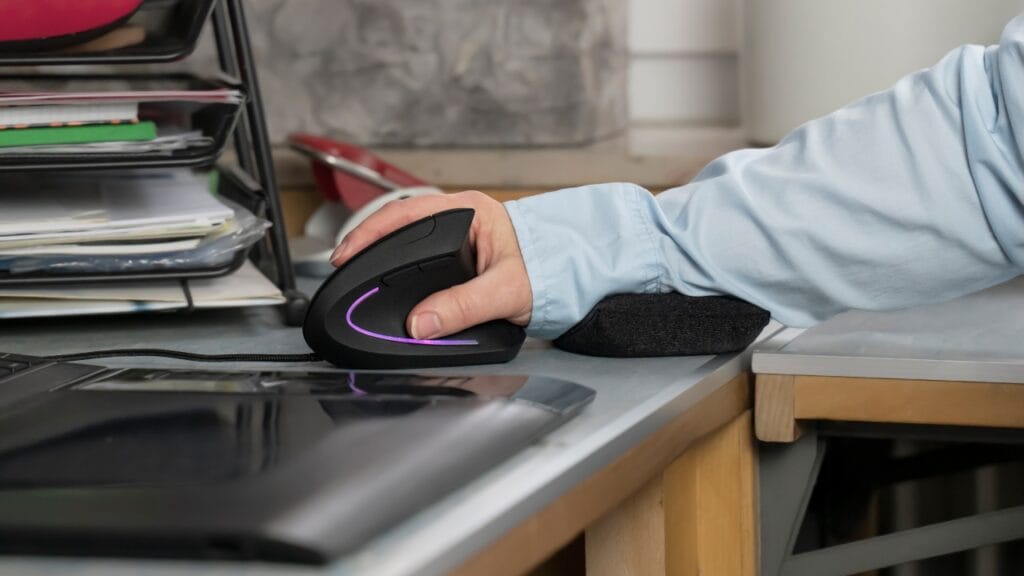 Suport ergonomic din spumă cu memorie – confort personalizat la fiecare mișcare Suport ergonomic pentru încheietură din spumă cu memorie folosit cu mouse vertical pe birou modern