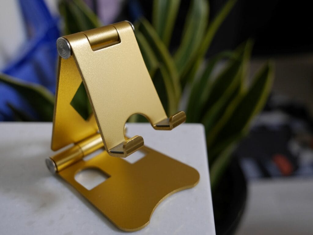Design modern pentru biroul tău – alege un suport care iese în evidență Suport de telefon auriu din aluminiu, pliabil, cu design modern și estetic