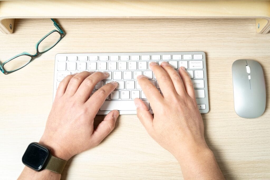 Tastatură wireless în utilizare – autonomie extinsă și eficiență energetică Kit tastatură și mouse wireless pe birou de lemn – autonomie mare a bateriei