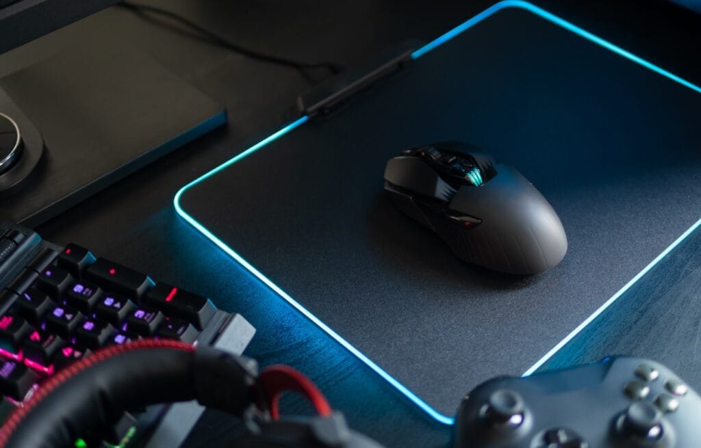 Ergonomia mouse-ului: cheia pentru gaming confortabil și performant Mouse ergonomic wireless pe mousepad iluminat RGB, setup de gaming performant