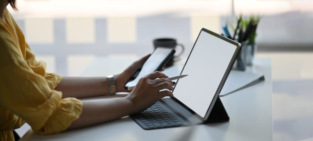 Transformă-ți tableta într-un mini-laptop cu o husă cu tastatură Persoană folosind o husă cu tastatură pentru tabletă, lucrând eficient într-un spațiu de birou modern