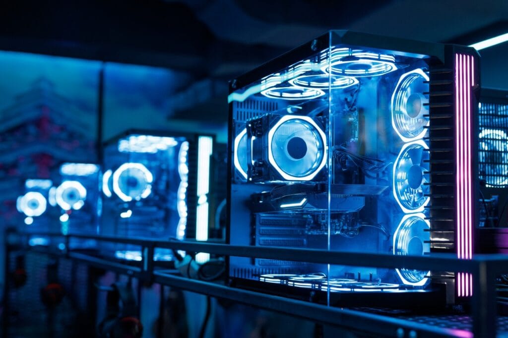 Iluminarea RGB e, fără îndoială, un subiect care împarte lumea pasionaților de PC-uri. Pentru unii, e acel „ceva” care face diferența între un sistem banal și unul care întoarce capete. Pentru alții, e doar o sursă de lumină inutilă care consumă energie și... eventual, nervi. Adevărul? E undeva la mijloc – și ține 100% de preferințele fiecăruia. Dacă te atrage ideea unui setup de gaming care pulsează în culori și îți reflectă personalitatea, atunci carcasele cu RGB integrat sunt exact ce trebuie. Modele precum be quiet! Pure Base 500 FX, AQIRYS Antares și DeepCool CH560 Digital vin deja echipate cu ventilatoare ARGB și controllere dedicate. Asta înseamnă că nu mai trebuie să investești suplimentar în iluminare sau în sisteme de control – totul e plug & play. În plus, sincronizarea efectelor cu placa de bază sau alte componente este de obicei simplă, mai ales dacă vrei un build coerent din punct de vedere vizual. Pe de altă parte, dacă îți dorești un sistem cât mai sobru și funcțional, carcasele Corsair 4000D Airflow sau nJoy Aura Black 2 s-ar putea să fie mai pe gustul tău. Nu vin cu lumini, dar compensează printr-un airflow excelent și un design curat, fără distrageri vizuale. Sunt genul de carcase care îți transmit un vibe de profesionalism – și uneori, mai puțin chiar înseamnă mai mult. NZXT H9 Flow, deși nu are iluminare RGB din fabrică, e ca o scenă perfectă pentru un spectacol de lumini dacă vrei să îți creezi singur acel look. Panourile mari din sticlă și spațiul generos din interior fac ca orice LED sau ventilator RGB adăugat ulterior să arate ca la vitrină. PC de gaming modern cu iluminare RGB albastră și carcasă transparentă