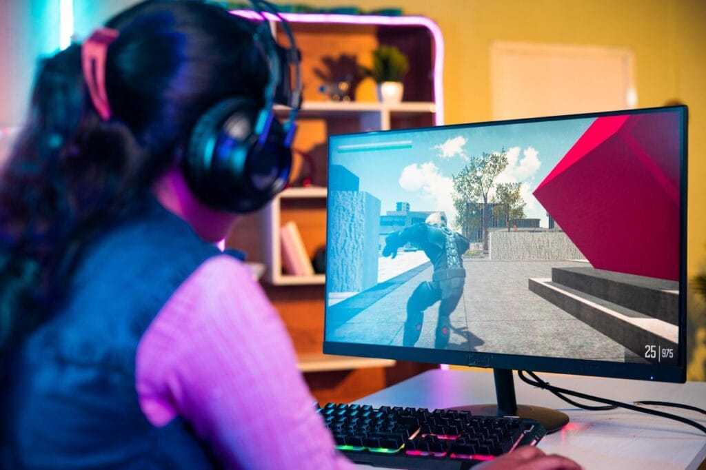 Experiența de gaming la 144Hz: Diferența se simte Femeie folosind un monitor de gaming cu rată de refresh ridicată pentru performanță în jocuri