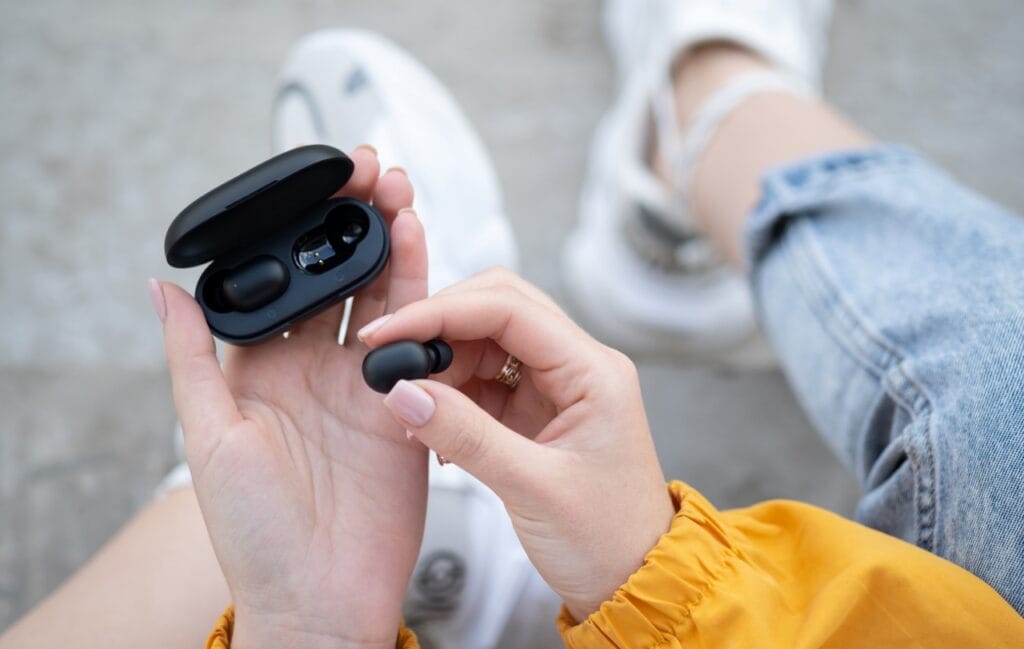 Ce înseamnă IPX pentru căști și cât de importantă este protecția împotriva apei Femeie folosind căști wireless rezistente la apă, ideale pentru utilizare zilnică în orice condiții meteo.