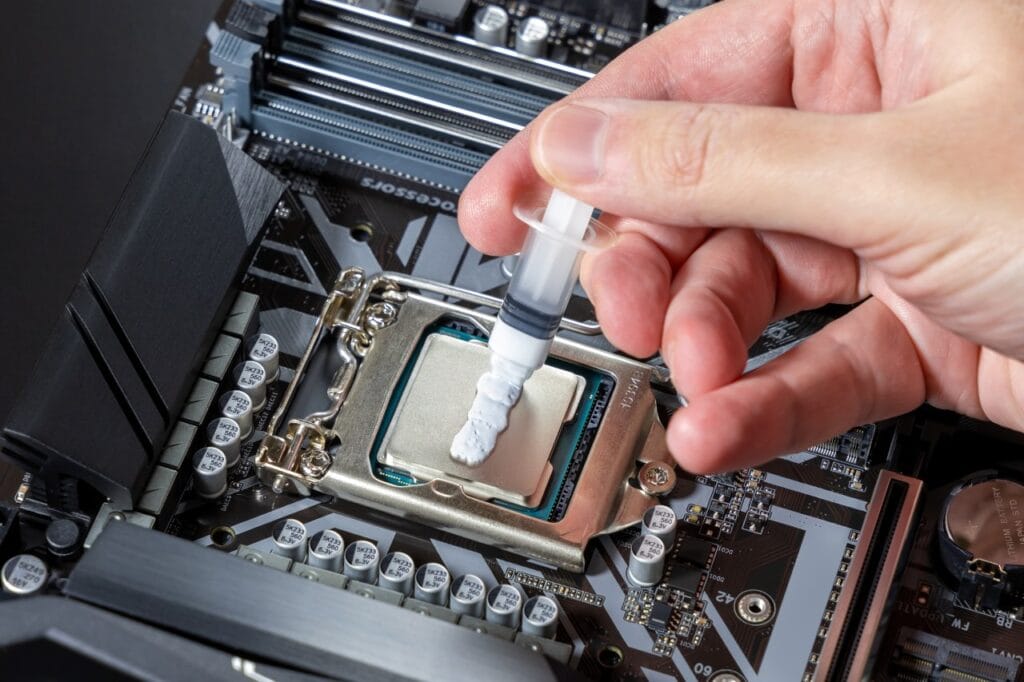 Aplicarea pastei termoconductoare: pas esențial pentru răcire eficientă Pasta termoconductoare aplicată pe procesor pentru îmbunătățirea contactului termic cu coolerul
