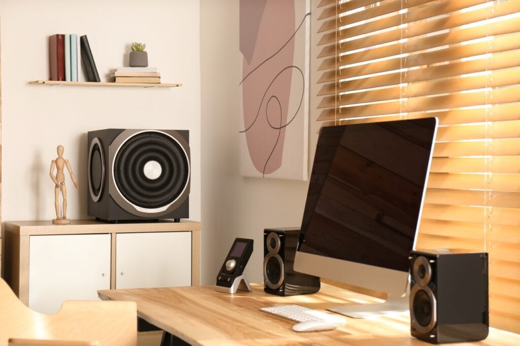 Subwooferul – cheia unui sunet cu adevărat imersiv Setup audio cu subwoofer mare activ într-un birou modern, pentru sunet imersiv și bass puternic
