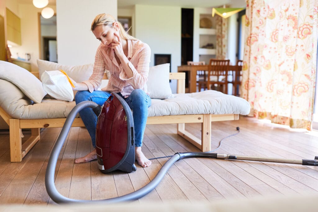 Alegerea unui aspirator eficient: mai puțini wați, aceeași performanță Persoană analizând un aspirator modern, reprezentând alegerea între consum redus și performanță optimă.
