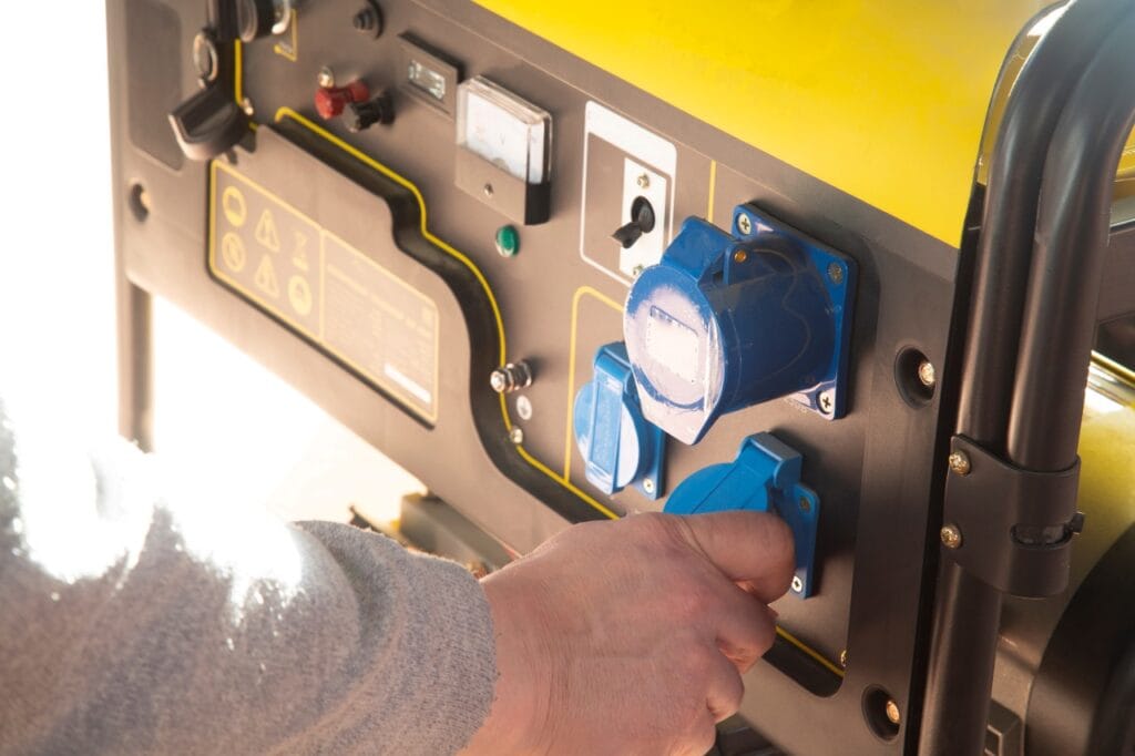 Generator dual-fuel – eficiență și flexibilitate în alimentare Persoană conectând un cablu la un generator dual-fuel cu prize albastre, ideal pentru alimentare pe benzină și GPL.