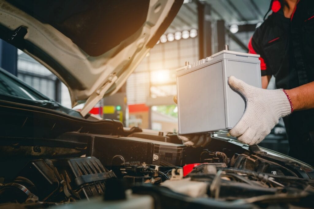 Înlocuire baterie auto – alegerea corectă în funcție de clim Tehnician auto schimbând bateria mașinii în service, important pentru funcționarea optimă la temperaturi extreme