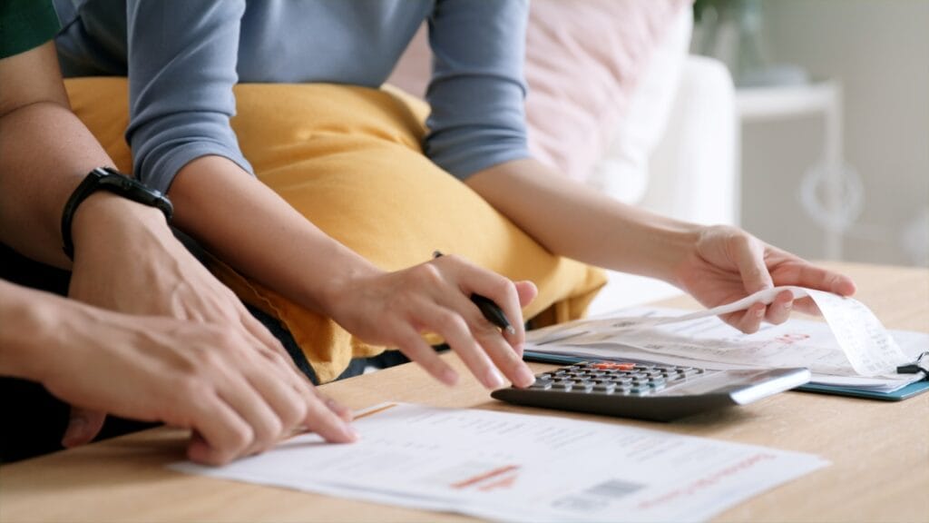 Finanțele în familie se construiesc cu încredere și implicare Cuplu analizând facturi și bonuri cu ajutorul unui calculator – organizare bugetară în gospodărie.