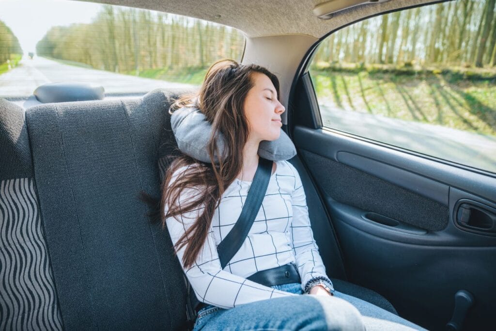 Perne pentru somn lateral sau dorsal – diferențe esențiale Fată dormind în mașină cu pernă de gât – exemplu de pernă pentru somn lateral