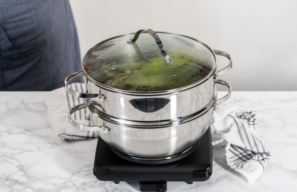 Oală steamer cu două nivele din inox, gătind legume la aburi, metodă dietetică și sănătoasă