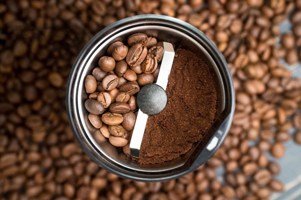 Râșniță de cafea electrică cu lamă, cu boabe întregi și cafea măcinată în același recipient, comparând metodele blade și burr