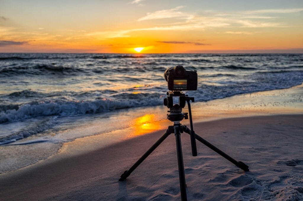 Trepied pe plajă la apus, echipament esențial pentru fotografie clară