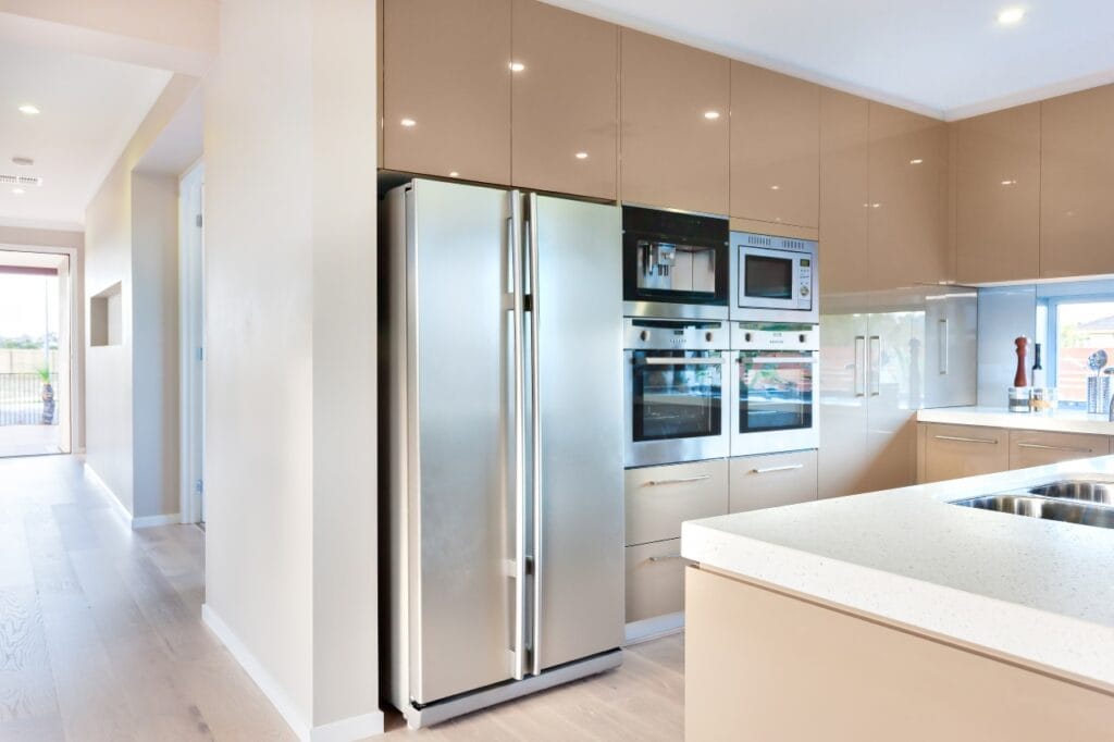 Cum să alegi finisajul potrivit pentru un frigider Side by Side de calitate Imagine cu frigider Side by Side din inox într-o bucătărie minimalistă cu electrocasnice moderne