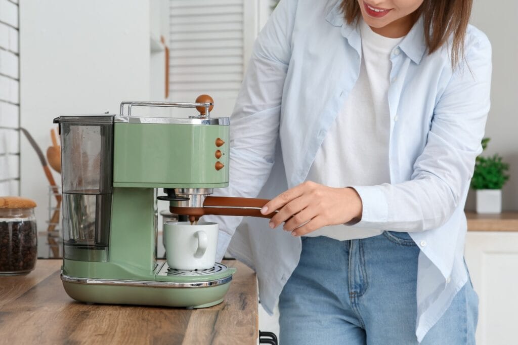 Sfaturi practice pentru a cumpăra un espressor bun la un preț corect Persoană preparând cafea la un espressor modern de bucătărie, ilustrare pentru ghid de economisire la cumpărarea unui espressor