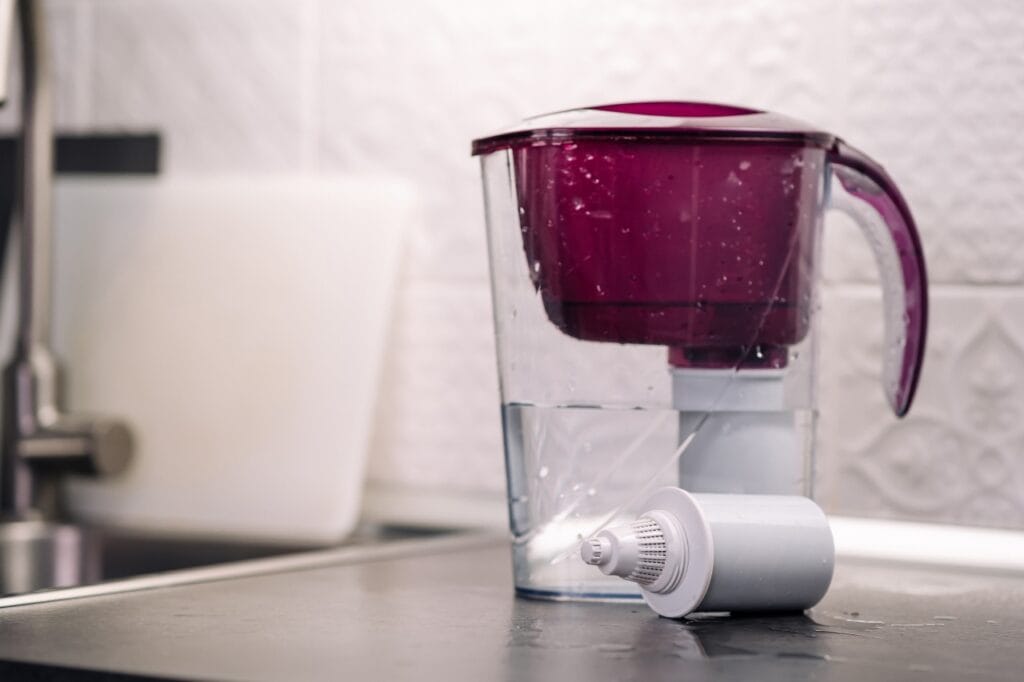 Cană de filtrare a apei pe blat, lângă un filtru de schimb, în proces de întreținere