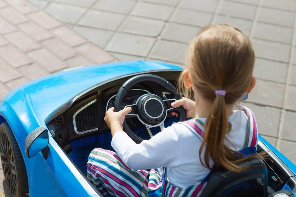 copil mic conducând mașinuță electrică cu baterie de 12V pentru autonomie mare