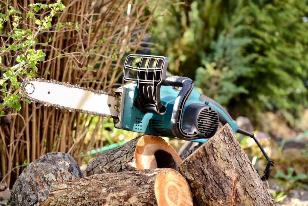 Drujbă electrică cu lamă de dimensiune medie, așezată pe bușteni, ideală pentru utilizare casnică și semi-profesională.