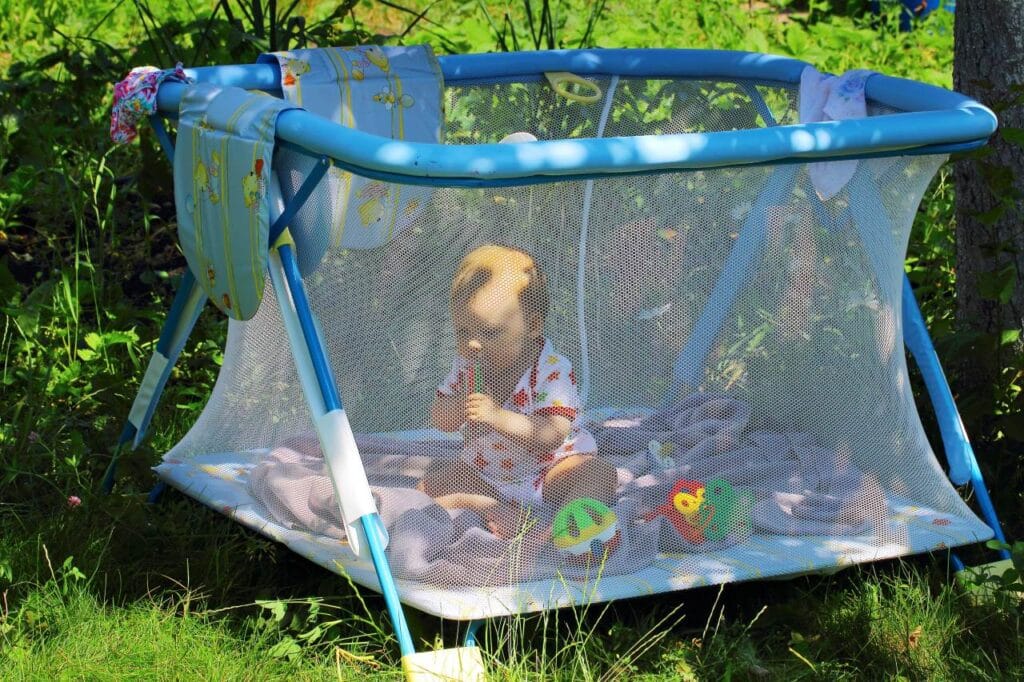 Țarc de joacă în aer liber, siguranță și supraveghere vizuală Bebeluș într-un țarc cu plasă de siguranță, amplasat afară, ideal pentru vizibilitate și protecție