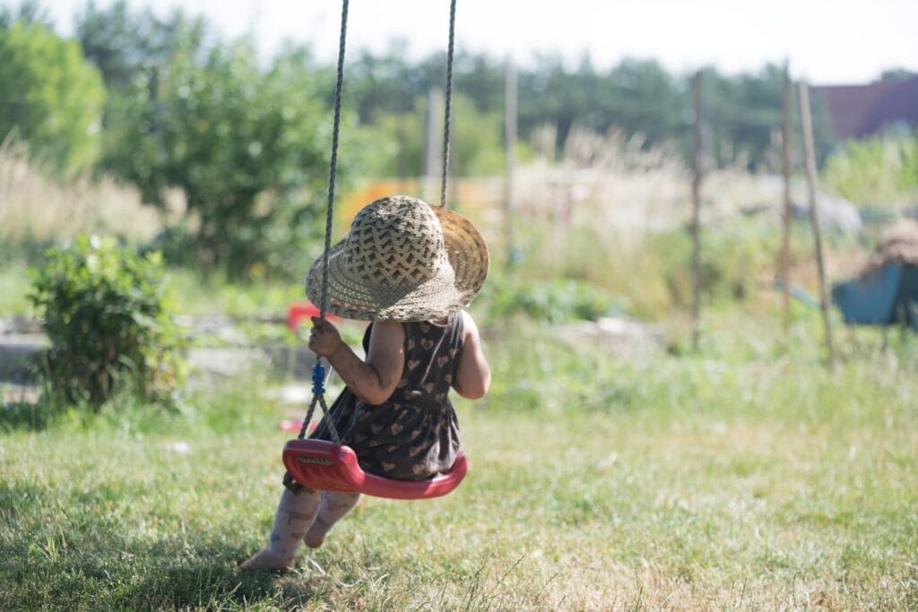 Reguli esențiale pentru joaca sigură la leagăn, chiar și în curte Siguranță la joacă pentru copii pe leagăn, curte cu iarbă, supraveghere și reguli de folosire corectă leagăne