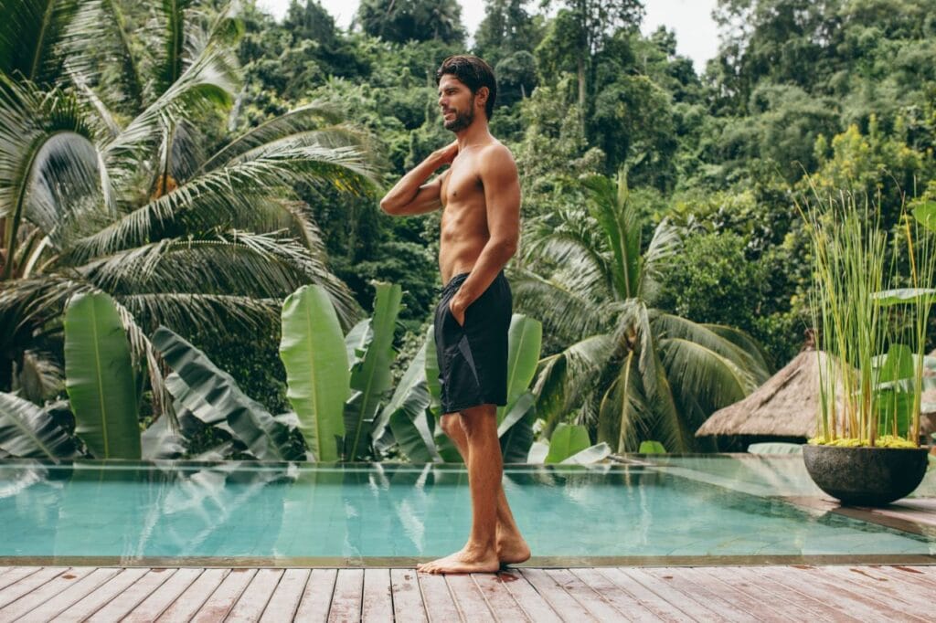 Costum de baie cu buzunare, alegerea practică pentru vară bărbat poartă șort de baie cu buzunare, funcționalitate la piscină tropicală