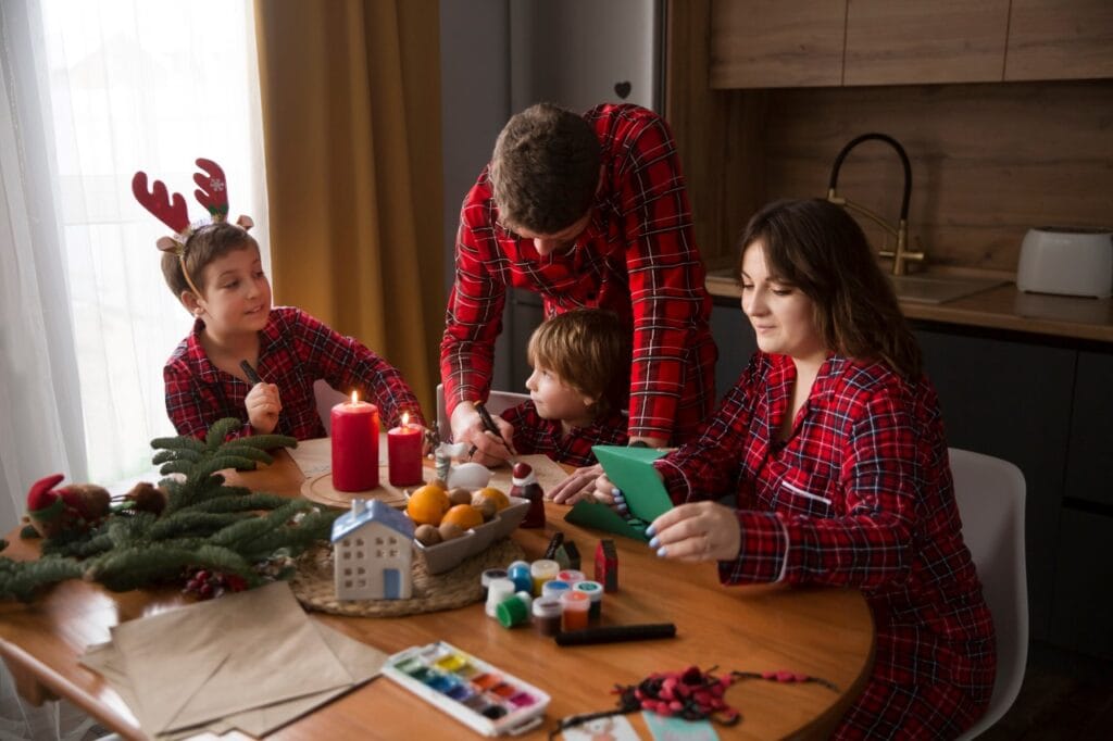 Familia în pijamale de Crăciun, trendul care aduce bucurie la fiecare vârstă familie poartă pijamale asortate de Crăciun la masă, activități de sărbători, pijamale carouri roșii