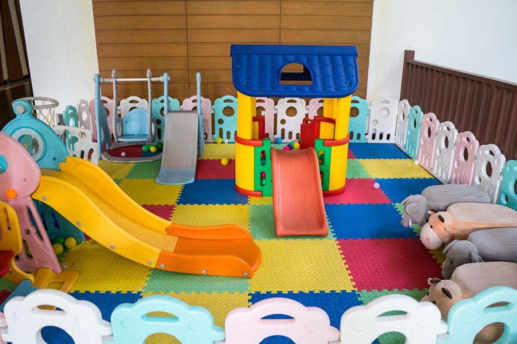 loc de joacă pentru copii amenajat în casă, structuri din plastic, tobogan galben și căsuță colorată