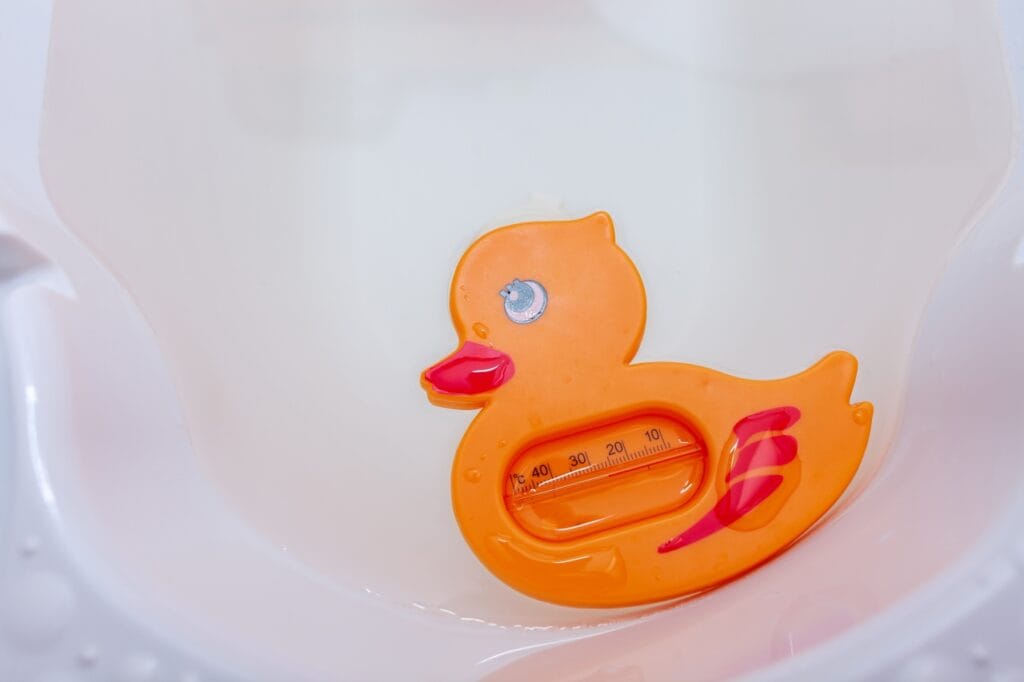 termometru baie bebeluși în formă de rață portocalie plutind în cadă, măsurare temperatură apă