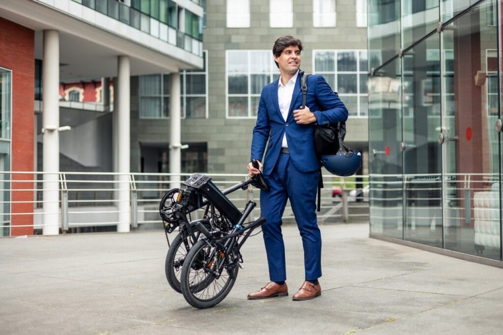 Mobilitate urbană inteligentă cu bicicleta pliabilă bărbat în costum cu bicicletă pliabilă, pregătit pentru transport intermodal urban