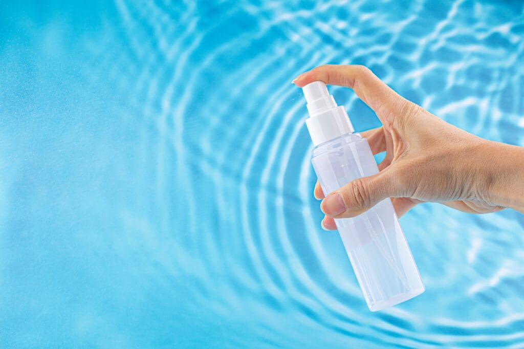 spray apă termală pe fundal de apă albastră, originea naturală influențează eficiența produsului pentru piele