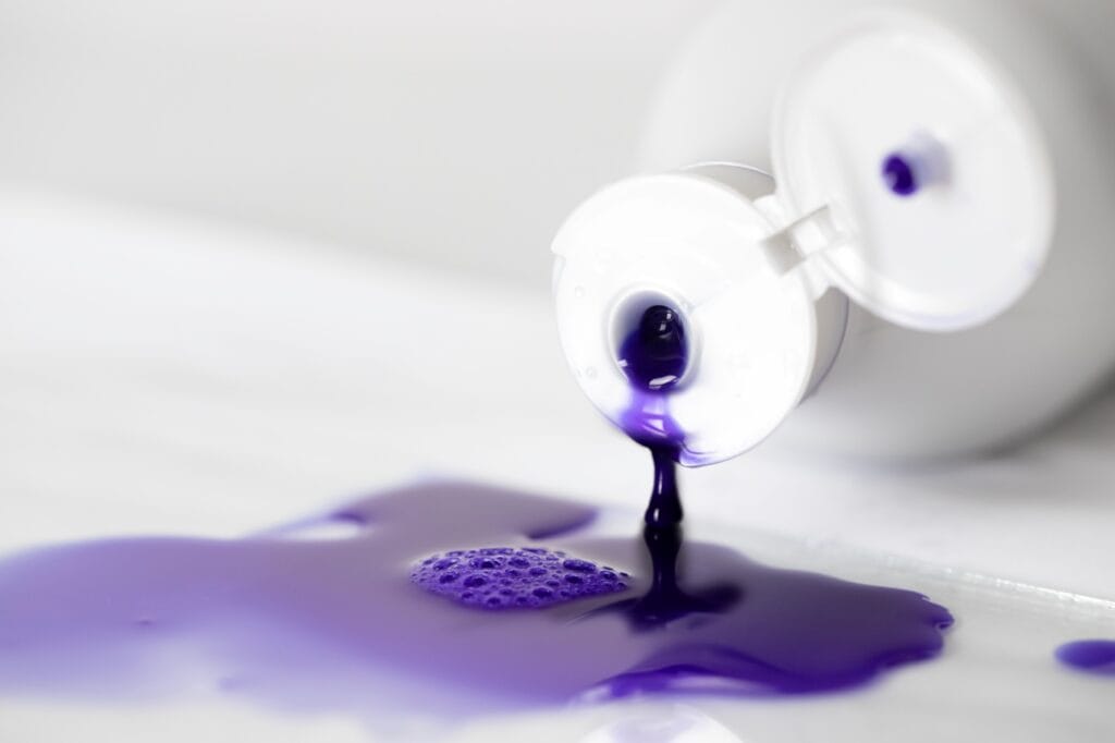 Pigmenți activi din șampon nuanțator în acțiune Pigmenți violet din șampon nuanțator vărsat pe suprafață, eficiență pentru păr blond sau decolorat