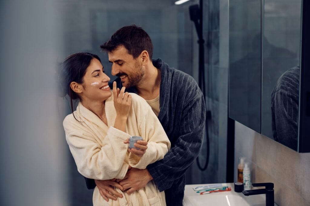 Hidratarea corectă pentru ten la 20, 30 sau 40+ cuplu aplicând cremă hidratantă în baie, îngrijire facială la orice vârstă