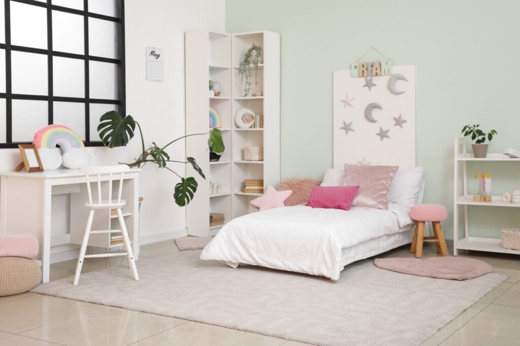 Camera copil, amenajată cu pat alb jos, accesorii pastel și decor creativ, ideală pentru confort și dezvoltarea imaginației.