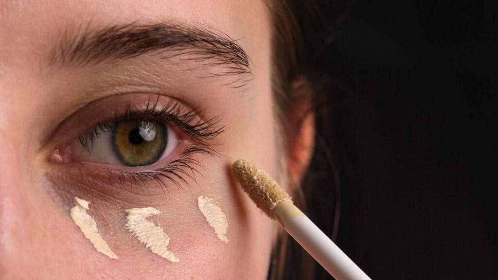 Protecție solară inteligentă: anticearcăn cu SPF pentru zona delicată a ochilor Femeie folosind anticearcan cu protecție solară pentru pielea sensibilă din jurul ochilor