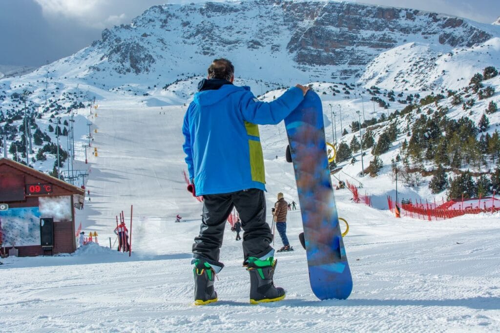 snowboarder echipat cu pantaloni eco friendly pe pârtie montană