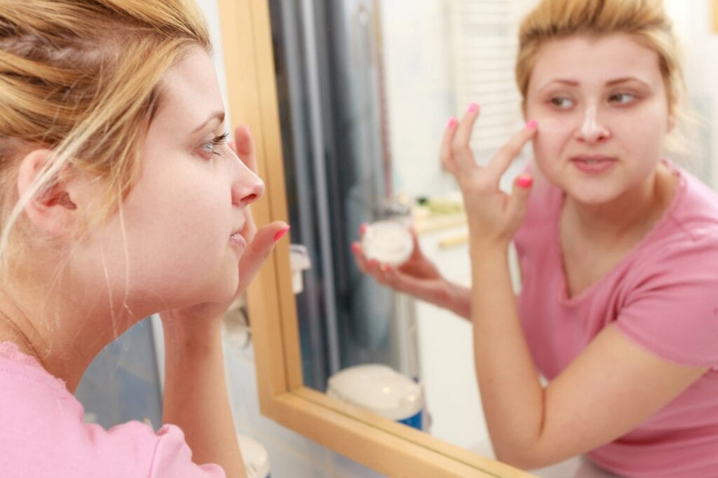 femeie aplică cremă hidratantă pentru ten gras conform sfaturilor dermatologilor