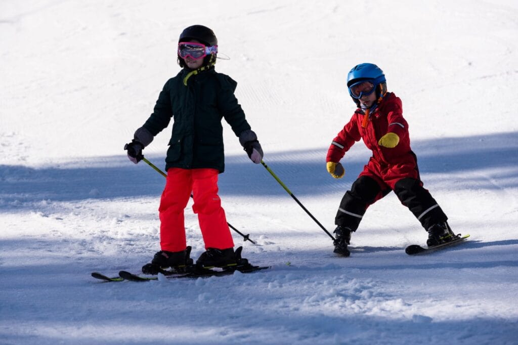 copii pe pârtie purtând ochelari de schi adaptați vârstei, siguranță și vizibilitate în sporturile de iarnă