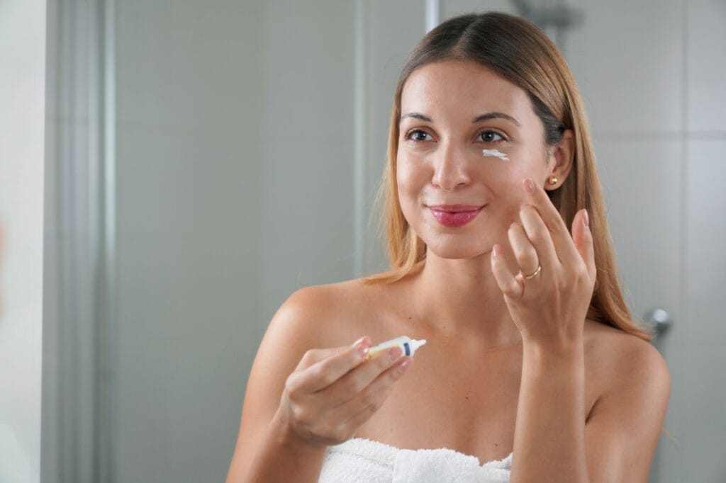 femeie aplică cremă sub ochi, importanța alegerii produselor fără ingrediente iritante