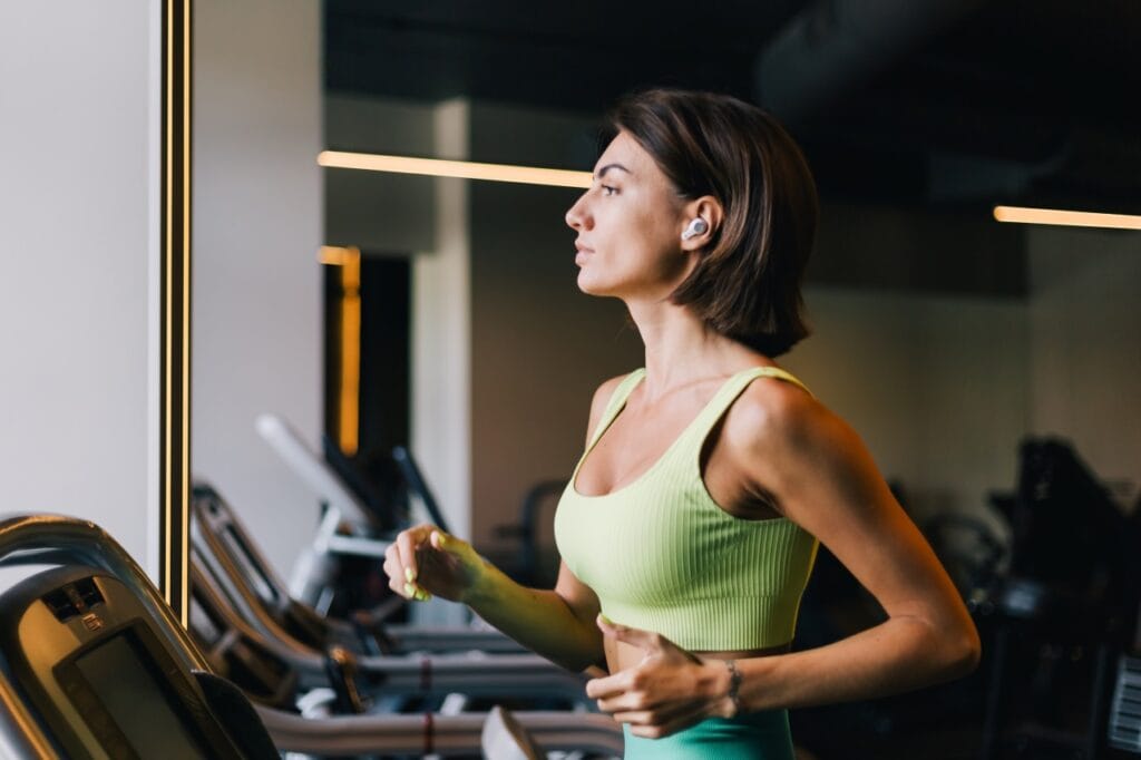 Diferențele dintre folosirea căștilor wireless în sală și la alergare în aer liber femeie antrenament sală cu căști wireless in-ear pentru fitness și alergare pe bandă