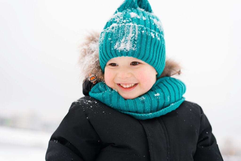 copil poartă guler tricotat din material călduros pentru iarnă, confort maxim la joacă în zăpadă