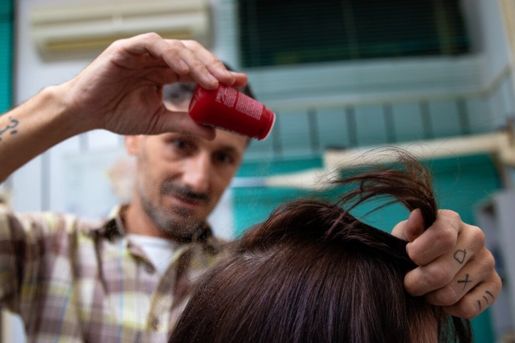 Cum combini pudra de volum cu alte produse de styling hairstylist aplicând pudră de volum în combinație cu alte produse de styling pentru păr voluminos