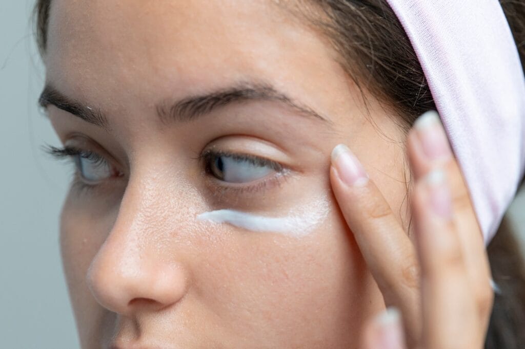 Aplicarea corectă a cremei de ochi cu masaj facial delicat Femeie aplică cremă de ochi cu masaj facial, tehnici pentru eficiență crescută