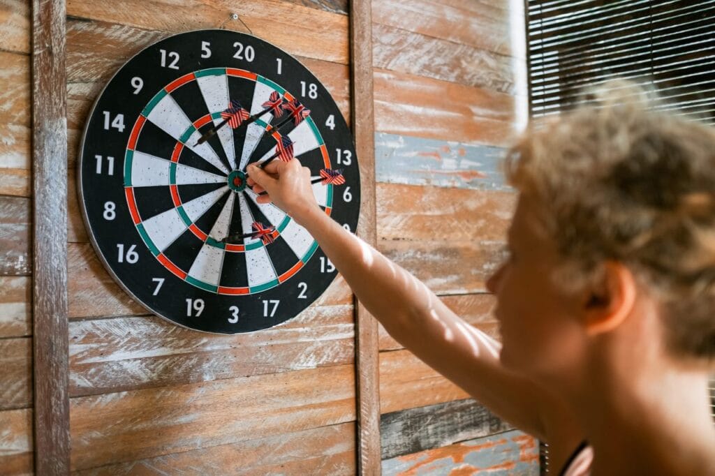 Diferența dintre boardurile de darts profesionale și cele de hobby în practică board de darts folosit acasă, arătând calitatea materialului și prinderea corectă