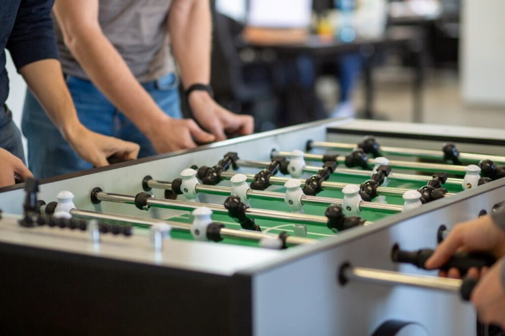 masă de foosball într-un birou folosită intens de mai mulți jucători